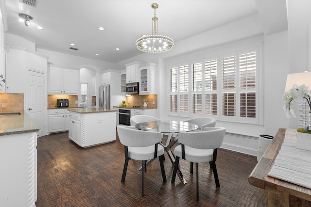 1891 Mustang Trl, Frisco, TX 75033 - dining room with arched walkways, a chandelier, and recessed lighting
