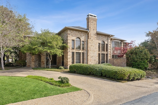 exterior space with a chimney and brick siding