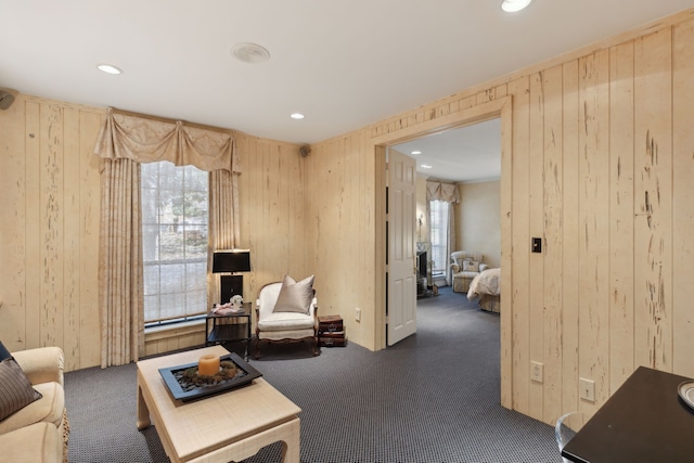 living room featuring carpet, wooden walls, and recessed lighting