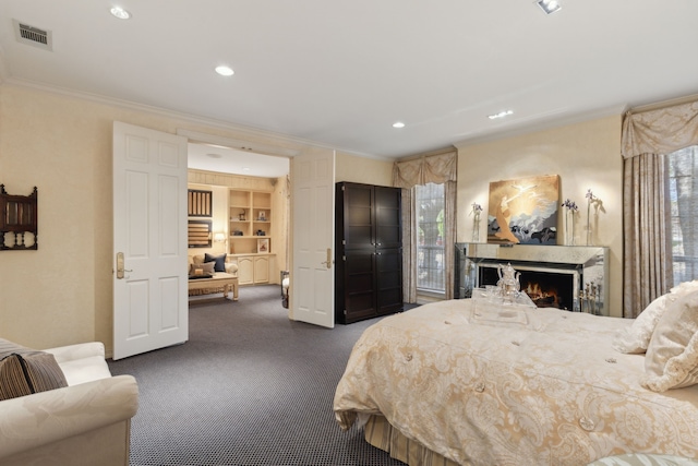 bedroom featuring a warm lit fireplace, visible vents, ornamental molding, recessed lighting, and dark colored carpet