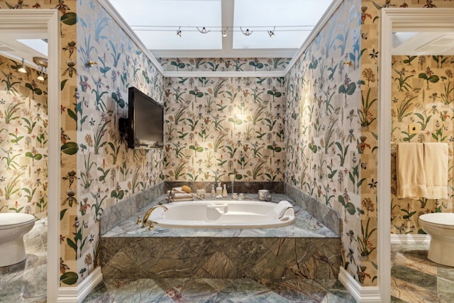 bathroom featuring marble finish floor, wallpapered walls, toilet, and a garden tub