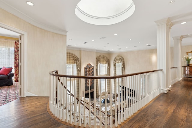 hall featuring ornate columns, ornamental molding, and wood finished floors