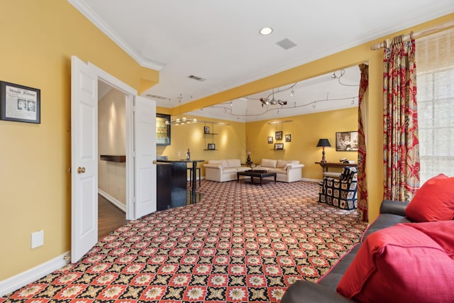 carpeted living room with baseboards, visible vents, crown molding, and track lighting