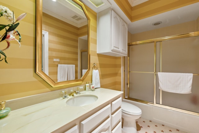 bathroom featuring toilet, vanity, combined bath / shower with glass door, and visible vents