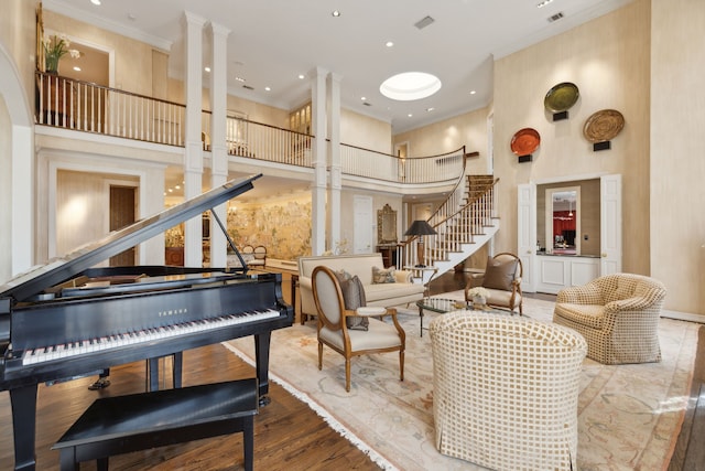 interior space with a towering ceiling, ornamental molding, and stairway