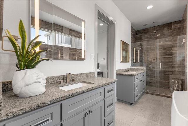 276 Currie St, Fort Worth, TX 76107 - bathroom with a shower stall, two vanities, a sink, and recessed lighting