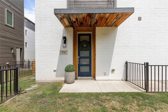 276 Currie St, Fort Worth, TX 76107 - view of exterior entry featuring brick siding and fence