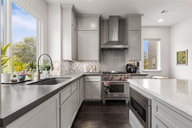 276 Currie St, Fort Worth, TX 76107 - kitchen featuring dark tile patterned floors, wall chimney range hood, backsplash, stainless steel appliances, and a sink