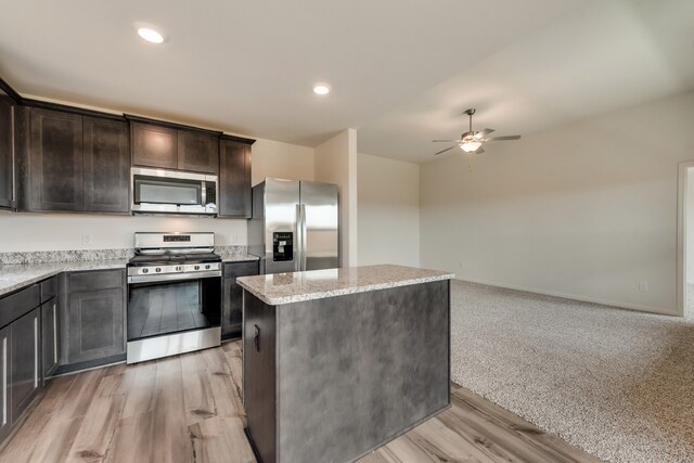 kitchen featuring stainless steel appliances, recessed lighting, a kitchen island, dark brown cabinets, and a ceiling fan