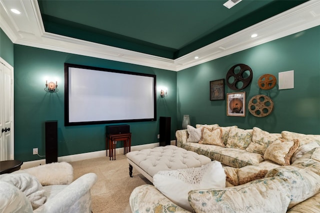 carpeted home theater room with a raised ceiling, crown molding, baseboards, and recessed lighting