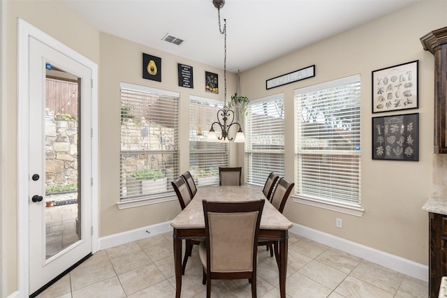 dining space with light tile patterned flooring, plenty of natural light, and baseboards