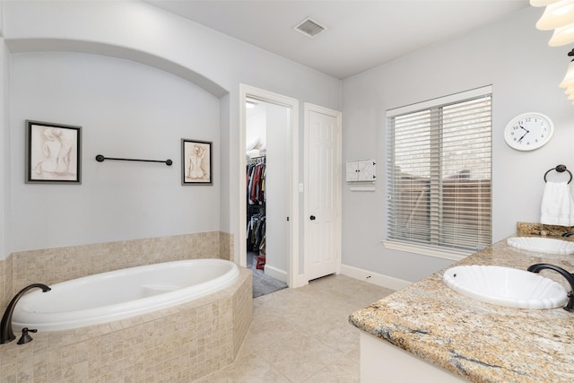 full bath featuring a garden tub, visible vents, a sink, and double vanity