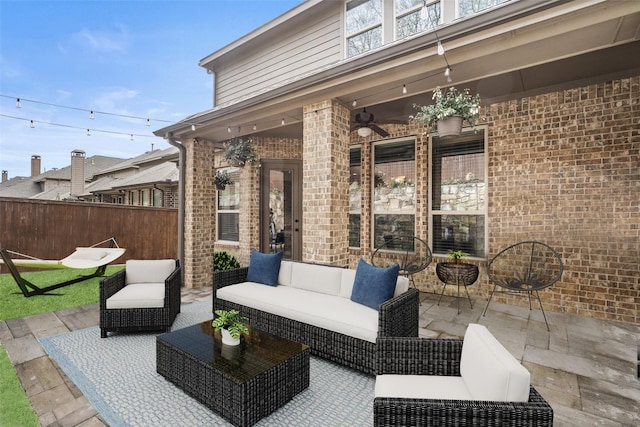 view of patio / terrace featuring a ceiling fan, fence, and an outdoor living space