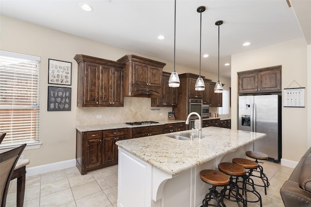 kitchen featuring a sink, decorative backsplash, dark brown cabinetry, baseboards, and appliances with stainless steel finishes