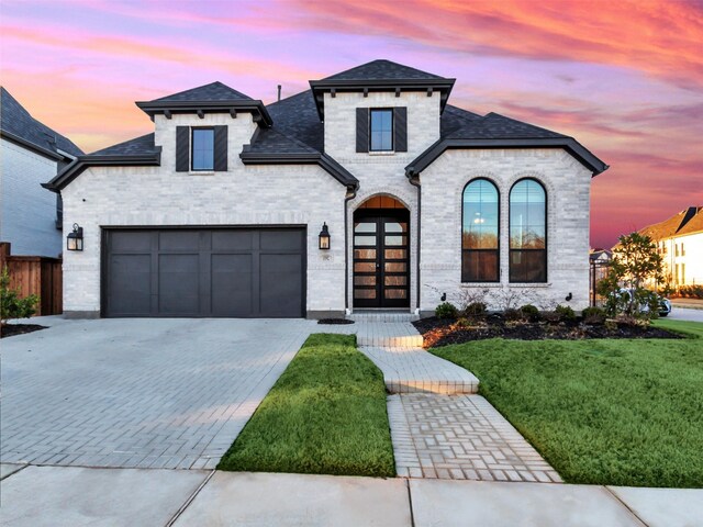 15592 Songbird St, Frisco, TX 75035 - french country style house with a yard, decorative driveway, roof with shingles, and brick siding