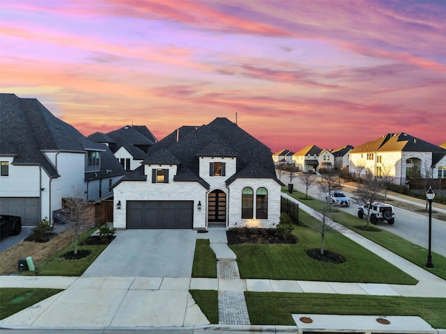 15592 Songbird St, Frisco, TX 75035 - french country inspired facade featuring a residential view, driveway, a front lawn, an attached garage, and stone siding