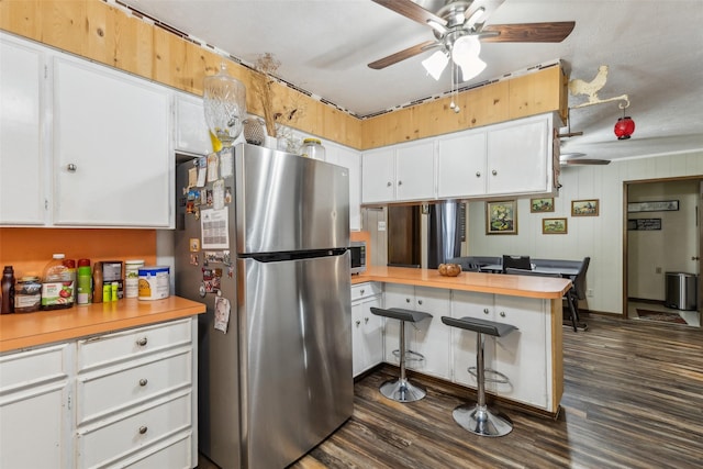 kitchen with a peninsula, white cabinetry, a ceiling fan, and appliances with stainless steel finishes