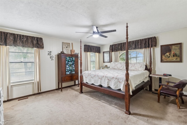 carpeted bedroom with multiple windows, ceiling fan, and a textured ceiling