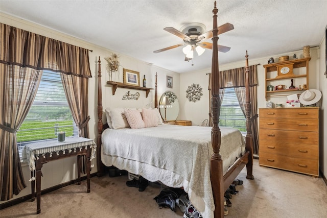bedroom with light carpet, crown molding, ceiling fan, and a textured ceiling