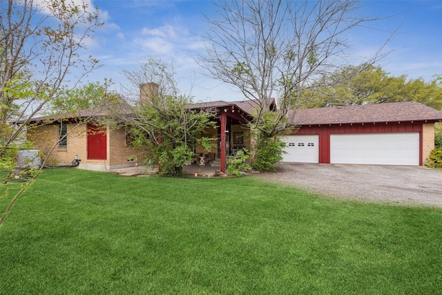 ranch-style house featuring brick siding, a front yard, driveway, and a chimney