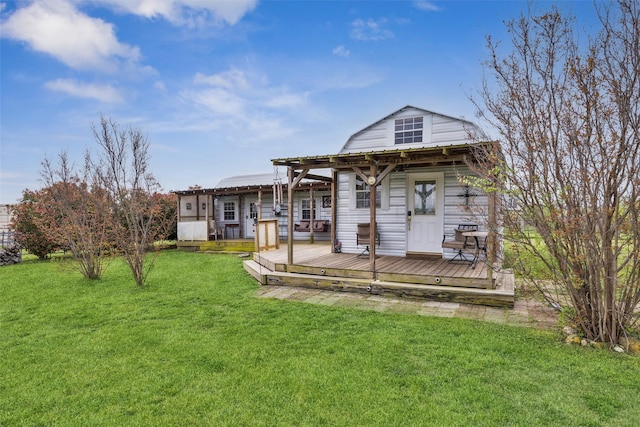 rear view of property with a gambrel roof, metal roof, a yard, and a wooden deck