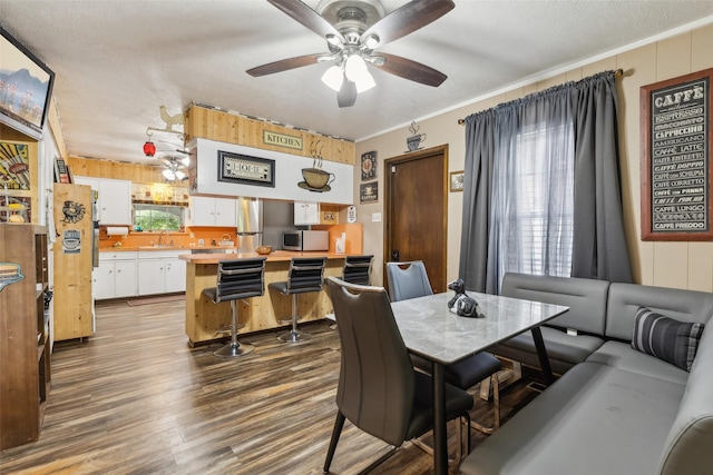 dining space featuring plenty of natural light, wood finished floors, ceiling fan, and ornamental molding