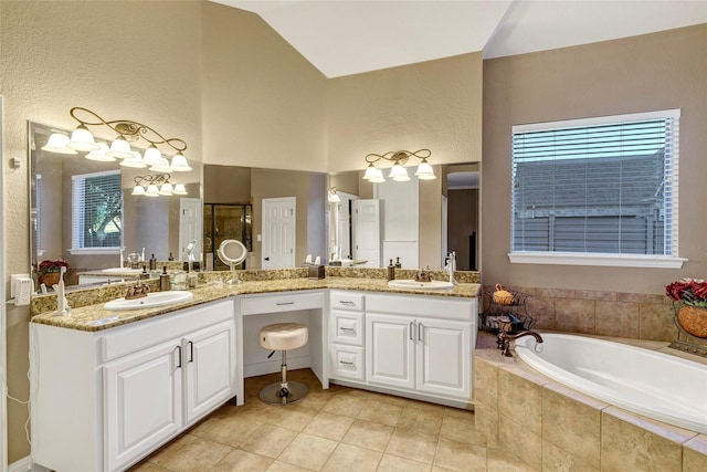 bathroom featuring tile patterned floors, a garden tub, vanity, and a healthy amount of sunlight