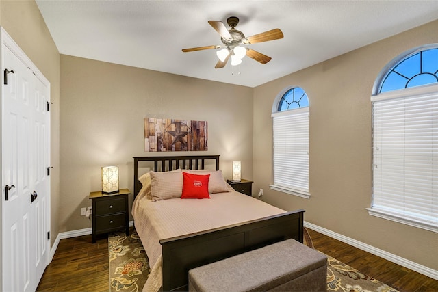 bedroom with baseboards, dark wood-type flooring, and ceiling fan