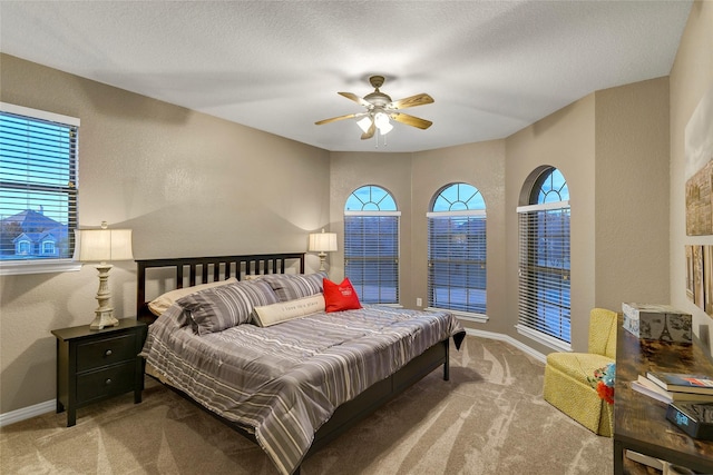 carpeted bedroom featuring a textured wall and baseboards