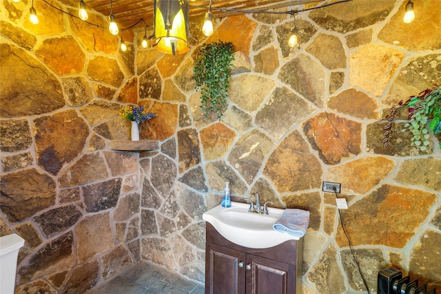 bathroom featuring wood ceiling, vanity, and stone finish flooring