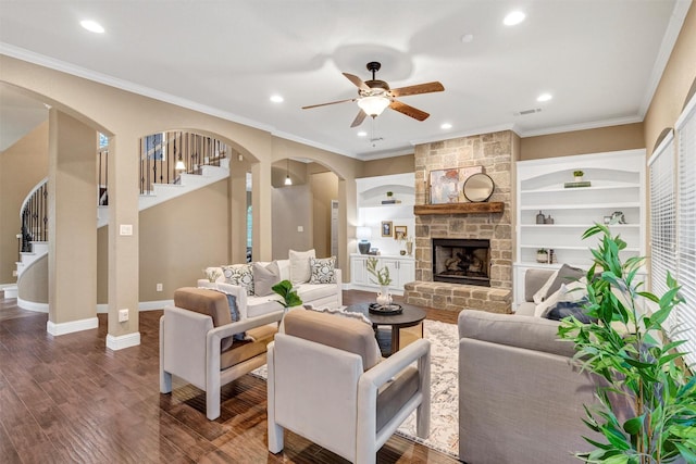 living area with crown molding, ceiling fan, arched walkways, visible vents, and dark wood-style floors