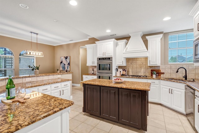 kitchen featuring stainless steel appliances, a sink, a center island, tasteful backsplash, and custom exhaust hood