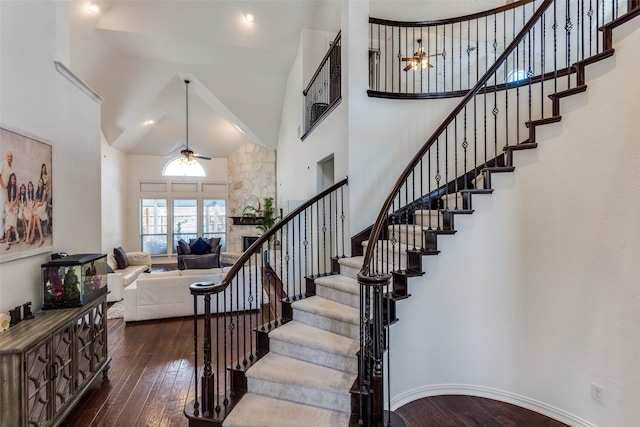 12532 Princess Dr, Frisco, TX 75035 - staircase with high vaulted ceiling, wood-type flooring, ceiling fan, a fireplace, and baseboards