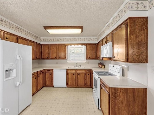 kitchen with white appliances, a textured ceiling, a sink, brown cabinetry, and light floors