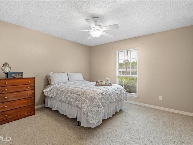 bedroom featuring light carpet, baseboards, and a textured ceiling