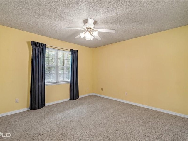 empty room with baseboards, ceiling fan, carpet flooring, and a textured ceiling