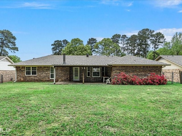 ranch-style home with a front yard, fence, and brick siding