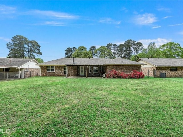 view of front of property featuring a front lawn, fence, and brick siding
