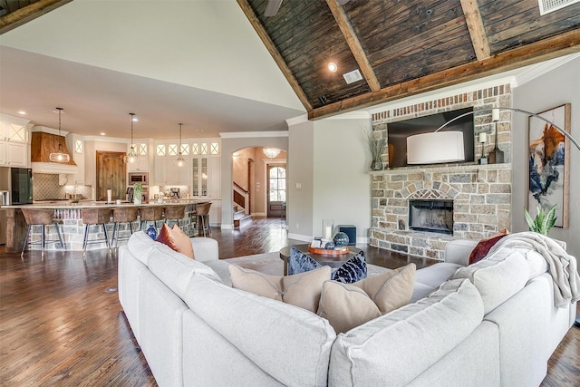 living room featuring high vaulted ceiling, dark wood-type flooring, baseboards, arched walkways, and ornamental molding