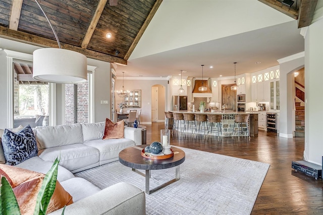 living room featuring arched walkways, crown molding, and baseboards
