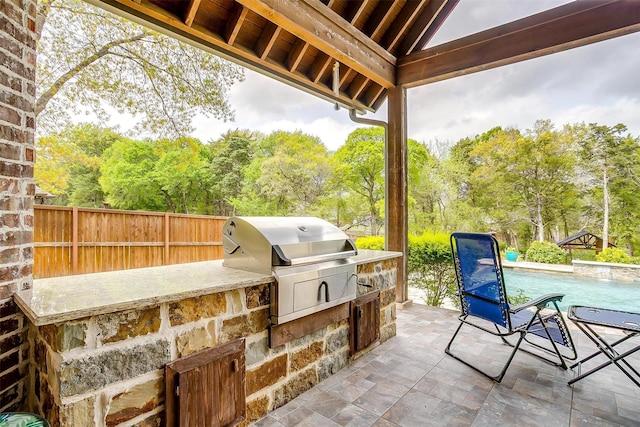 view of patio with fence, an outdoor kitchen, and area for grilling