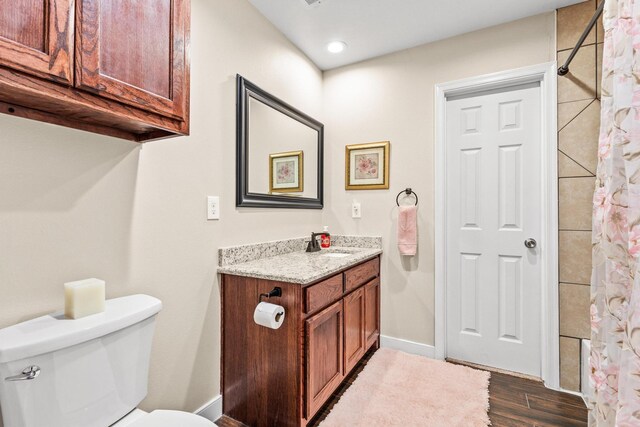 1321 S Montgomery St, Sherman, TX 75090 - bathroom featuring toilet, vanity, wood finished floors, a shower with shower curtain, and baseboards