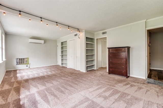302 Comanche Dr, Gainesville, TX 76240 - unfurnished living room with crown molding, carpet flooring, visible vents, and a wall mounted AC