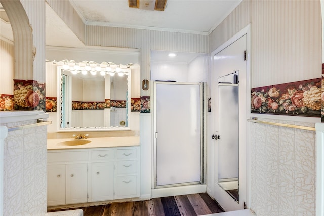 302 Comanche Dr, Gainesville, TX 76240 - full bathroom with a shower stall, vanity, crown molding, wallpapered walls, and wood finished floors