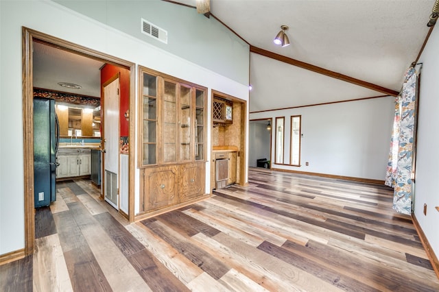 302 Comanche Dr, Gainesville, TX 76240 - unfurnished living room with a sink, visible vents, wood finished floors, and baseboards