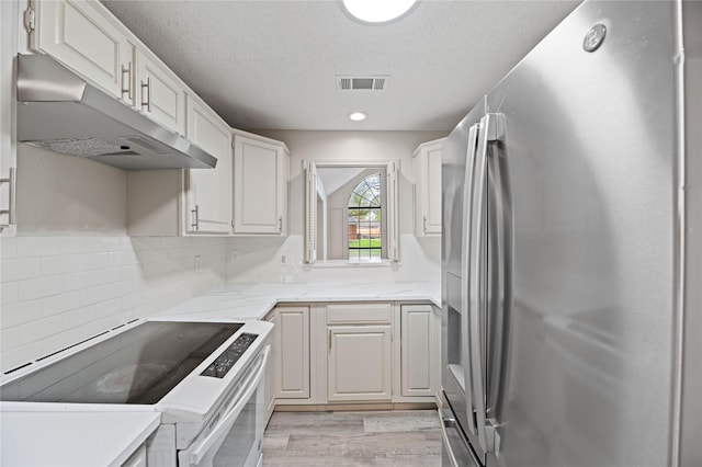 1581 Glenmore Dr, Lewisville, TX 75077 - kitchen with white cabinets, stainless steel refrigerator with ice dispenser, under cabinet range hood, range with electric stovetop, and visible vents