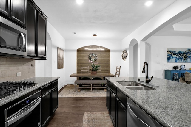 14649 Martin Creek Cv, Fort Worth, TX 76262 - kitchen with a sink, stainless steel appliances, dark cabinetry, tasteful backsplash, and dark wood-style flooring