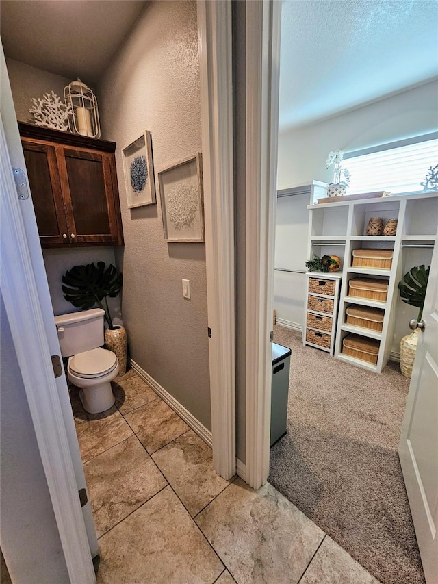 4805 Saddleback Ln, Wichita Falls, TX 73608 - bathroom with toilet, a textured wall, baseboards, and tile patterned floors