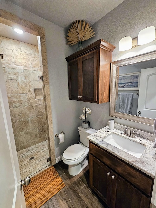 4805 Saddleback Ln, Wichita Falls, TX 73608 - bathroom with a stall shower, wood finished floors, toilet, vanity, and baseboards