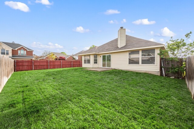 8329 Rolling Rock Dr, Fort Worth, TX 76123 - back of property with a fenced backyard, a chimney, a yard, and a patio area